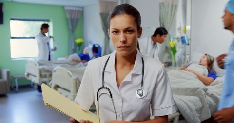 Confident Doctor Holding Report in Busy Hospital Ward - Download Free Stock Images Pikwizard.com