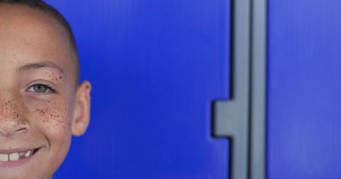 Smiling Biracial Boy with Freckles, Blue Background, Cheerful Mood