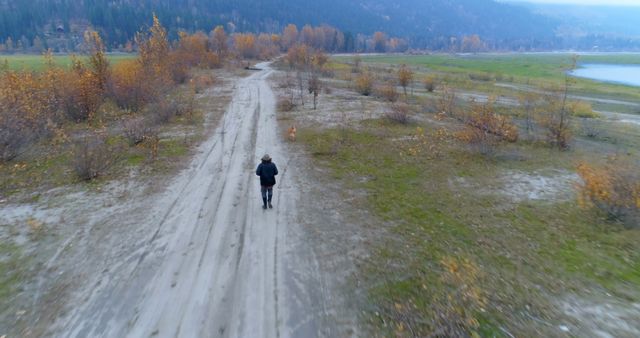 Person Walking on Nature Trail in Autumn Landscape - Download Free Stock Images Pikwizard.com