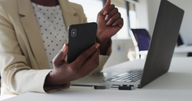 Close up of hands of african american businesswoman using smartphone. independent creative business at a modern office.