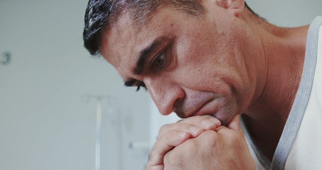 Middle-aged man in deep thought, showing serious and reflective expression, indoors. Can be used to convey emotions like worry, stress, or introspection. Ideal for articles or content related to mental health, personal reflection, or emotional well-being.