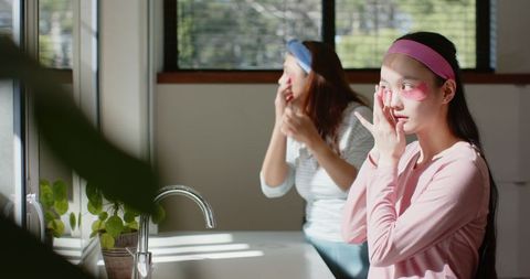 Mother and daughter bonding applying under-eye gel patches