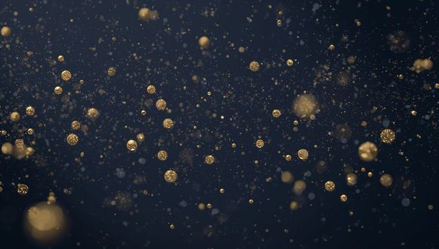 Golden bokeh particles floating on dark navy backdrop for luxury abstract designs
