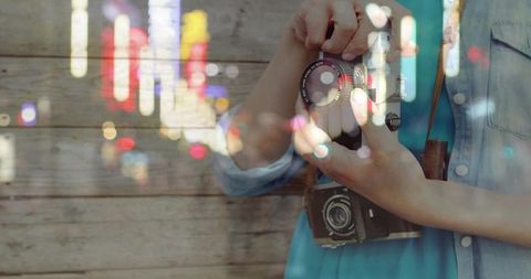 Artistic photographer adjusting camera lens with city lights