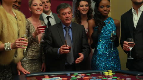 Group Celebrating at Casino Craps Table with Drinks and Chips