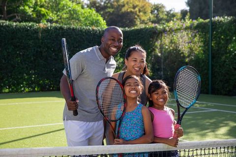 Diverse family enjoying tennis adventure on sunny day
