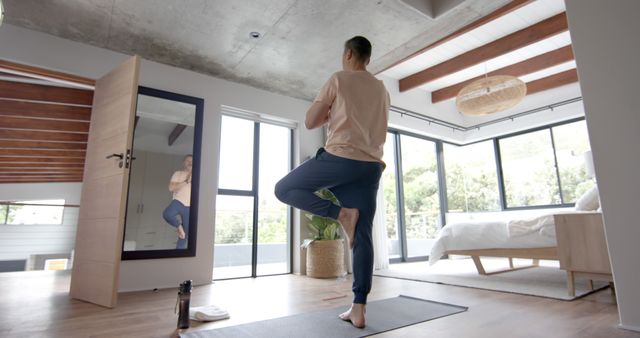 Man Practicing Yoga at Home in Spacious Modern Bedroom - Download Free Stock Images Pikwizard.com