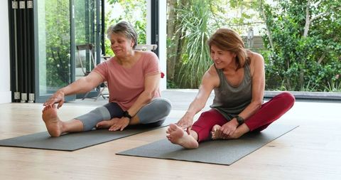 Women Practicing Yoga Indoors Building Flexibility and Friendship