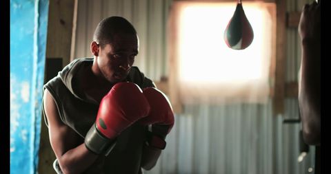 African american boxer training in fitness studio