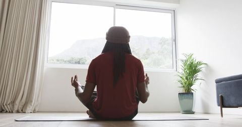 African American Man Meditating at Home Facing Window Minimalist Yoga Mindfulness Wellness