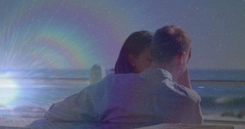 Romantic Couple Relaxing by Ocean with Sunflare