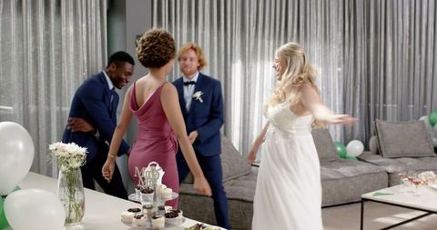 Joyful Wedding Guests Dancing at Living Room Celebration