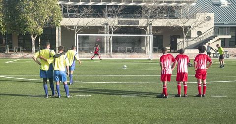 Youth soccer players preparing for free kick on school field