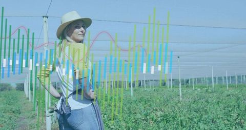 Woman farmer surveying net-covered crop rows with precision agriculture data overlay