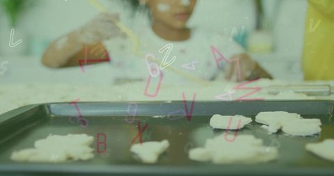 African American Girl Baking Cookies with Alphabet Overlay