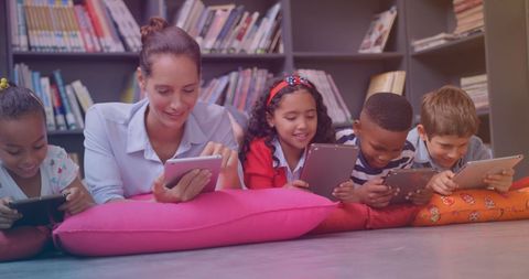 Teacher Engaging with Diverse Students Using Tablets in Library