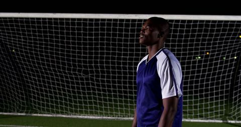 Soccer Player Practicing at Night on Field in Blue Jersey