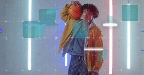 Teen in Futuristic Neon Studio Holding Basketball