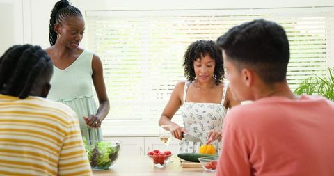 Friends Enjoying Cooking Together Preparing Fresh Salad in Kitchen