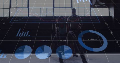 Silhouette athletic duo training with battle ropes backlit in industrial gym hud overlays