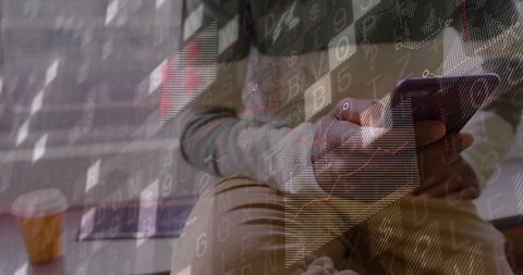 Man checking smartphone in cafe with financial analytics overlay, tablet and coffee