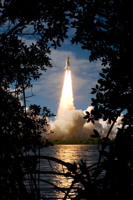 This iconic scene captures the Space Shuttle Atlantis launching toward the International Space Station from Kennedy Space Center, Florida on November 16, 2009. Featuring dramatic plume and smoke, with reflective water in foreground, the composition is powerful for illustrating space exploration, space missions, history of spaceflight, or science education. Ideal for educational material, documentary purposes, or illustrating articles about NASA advancements.