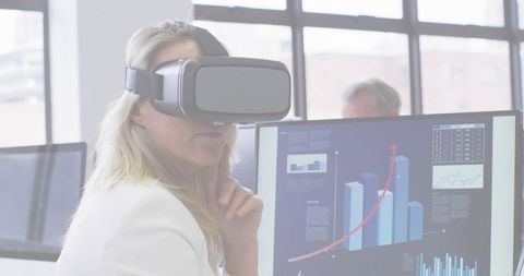 Businesswoman Analyzing Data with VR Headset in Modern Office