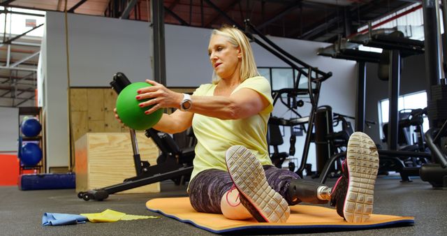 Active Senior Woman with Prosthetic Leg Exercising with Medicine Ball in Gym - Download Free Stock Images Pikwizard.com