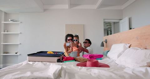 Family Packing Suitcase in Hotel Room for Exciting Vacation
