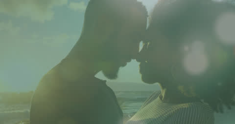 Romantic Couple Enjoying Sunset on Beach with Light Effects