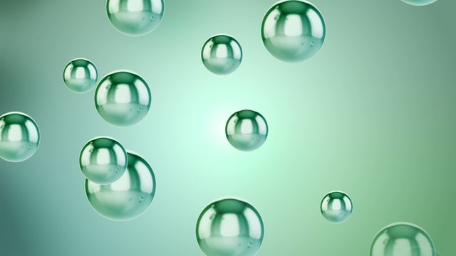 Several green bubbles are suspended and floating upward against a light green background. This abstract image signifies calmness and serenity and is perfect for use in backgrounds, graphic design, scientific presentations, or environmental contexts.