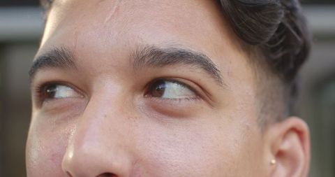 Close-Up Portrait of Man with Introspective Gaze Through Blurred Slats