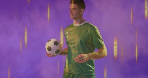 Soccer Player Holding Ball in Vibrant Amber and Purple Light