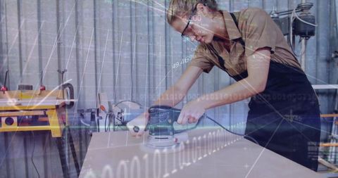 Craftswoman Using Orbital Sander in Workshop with Binary Overlay