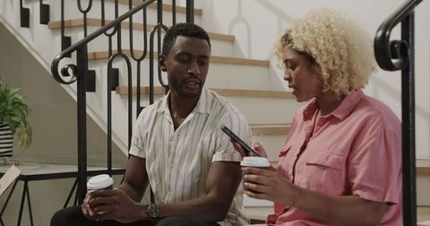 Couple Sharing Coffee and Bonding on Stairway