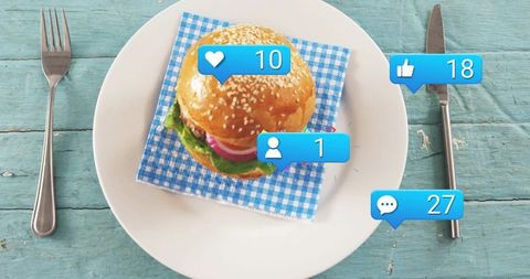 Social media styled sesame burger featuring like, comment bubbles on rustic blue table