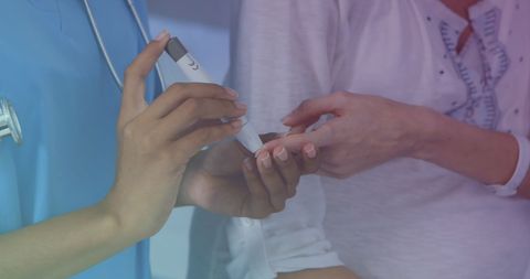 Nurse assisting patient with glucose meter usage for diabetes care
