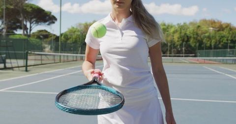 Female Tennis Player Balancing Tennis Ball on Racket on Sunlit Outdoor Court