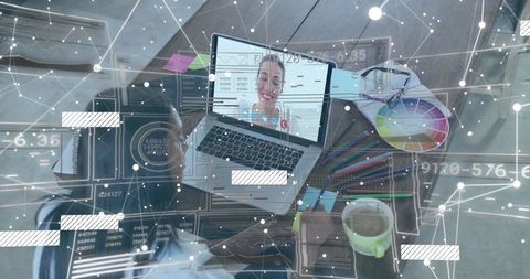 Creative professional working from home on video call with laptop, color wheel, markers