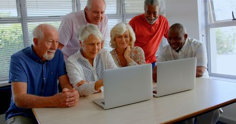 Diverse Senior Friends Engaged with Laptops in a Group Setting