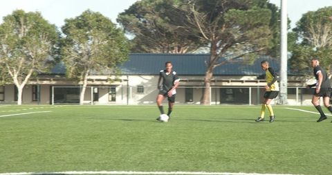 Soccer player kicking ball on field amidst game strategy
