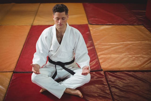 Karate player practicing yoga in fitness studio