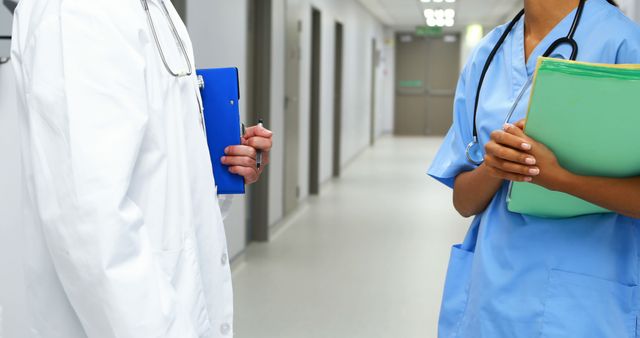 Healthcare Professionals Discussing Patient Charts in Hospital Corridor - Download Free Stock Images Pikwizard.com