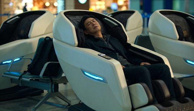 Business traveler sleeping in futuristic massage pod at airport terminal