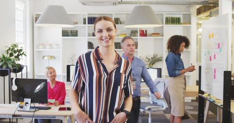Confident Businesswoman Leading Creative Team in Office
