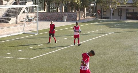 Young soccer players practicing on field in sunshine