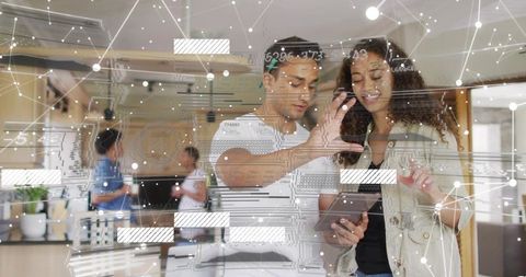 Collaborating professionals using tablet with augmented data overlay in office kitchen