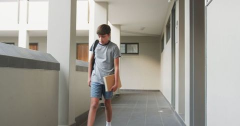 Teen Boy Walking in School Hallway with Backpack and Folder - Download Free Stock Images Pikwizard.com