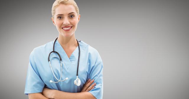 This image depicts a confident female doctor standing with arms crossed, smiling at the camera. She is wearing a blue medical uniform and has a stethoscope around her neck. This image can be used for healthcare-related websites, medical blogs, hospital brochures, and promotional materials for medical services.
