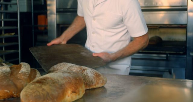 This image can effectively illustrate professions within the food industry, specifically the role of a baker. Perfect for use in articles or marketing materials related to baking, culinary arts, or a behind-the-scenes look at the food preparation process.